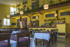 フネドアラにあるHotel Maierの黄色い壁の部屋にテーブルと椅子が備わるレストラン