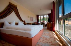 a hotel room with a bed and a large window at Hotel Burgblick in Hochburg-Ach