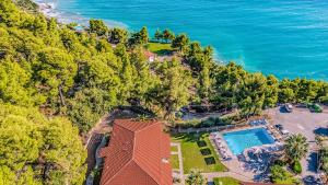 an aerial view of a house with a swimming pool and the ocean at Thea Hotel in Possidi