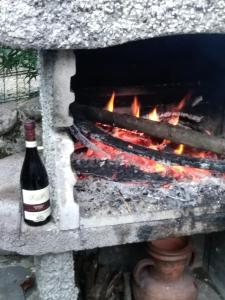 a bottle of wine sitting next to a fire at Casetta in Pontremoli