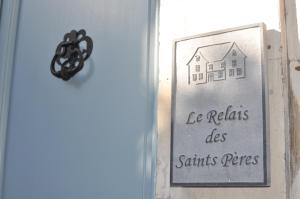 een bord op een deur met een huis erop bij B&B Le Relais des Saints Pères in Auxerre