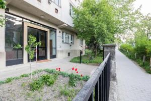 ブダペストにあるNemetvolgyi Apartmentの柵と赤い花が並ぶ建物
