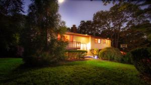 una casa por la noche con las luces encendidas en Nice 4bdr all Q size,IG Pool,Billiard, en Hampton Bays