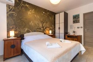 1 dormitorio con 1 cama con 2 toallas en Apartments & rooms DDD2, en Baška