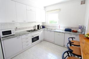 エンプリアブラバにあるLEON INMO Villa Gabriela - 10034の白いキッチン(白いキャビネット、テーブル付)