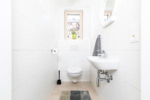 a white bathroom with a toilet and a sink at Top of Innsbruck in Innsbruck +7 photos