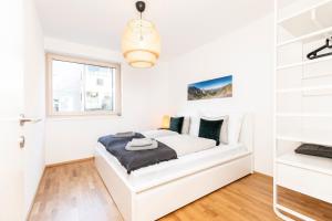 a white bedroom with a bed and a window at Top of Innsbruck in Innsbruck