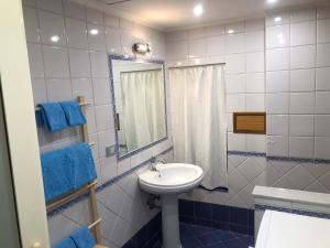 y baño con lavabo, espejo y toallas azules. en Casa Gamilia, en Nápoles