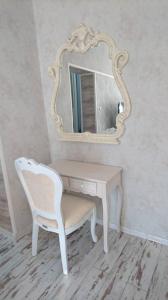 a dressing table with a chair and a mirror at Апартамент Барок in Lovech