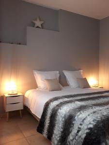 1 dormitorio con 1 cama blanca grande y 2 lámparas en Panda Parc Appartment proche Pairi Daiza-Shape-Nato, en Lens