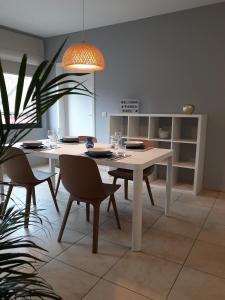 a dining room with a white table and chairs at Panda Parc Appartment proche Pairi Daiza-Shape-Nato in Lens