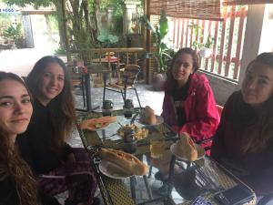 a group of girls sitting at a table with food at Tam Coc Green Fields Homestay in Ninh Binh +30 photos