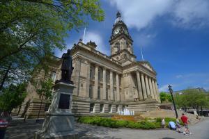 a building with a clock tower in front of it at Bolton Executive Apartment in Bolton