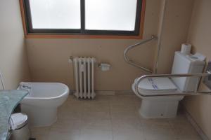 a white toilet sitting next to a window in a bathroom at Hotel Gran Via in Zaragoza