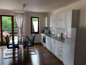 a kitchen with a dining table and a refrigerator at Apartmán Tatiana in Terchová