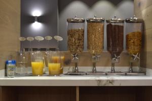 a counter with glasses of cereal and orange juice at Hotel Gran Via in Zaragoza
