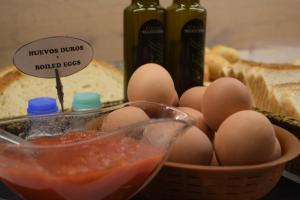 un tazón de huevos junto a una cesta de pan en Hotel Gran Via en Zaragoza