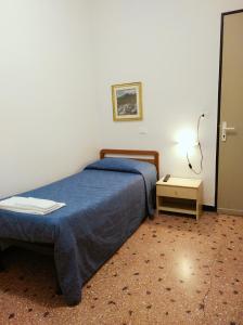 a bedroom with a blue bed and a night stand at Hotel Suisse in Sestri Levante