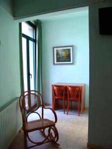 サンタ・コロマ・デ・ファルネルスにあるHotel Pinxoのテーブルと椅子2脚、窓が備わる客室です。