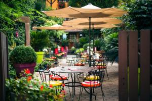 a group of tables and chairs under an umbrella at Hôtel des Deux Clefs in Turckheim