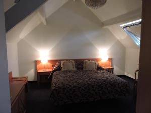 - une chambre avec un lit et deux lumières sur le mur dans l'établissement Manoir thoveke, à Lauwe