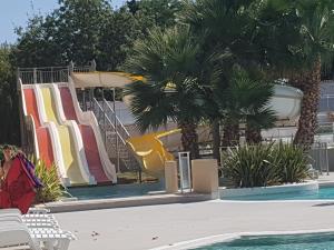 a resort with a slide and a swimming pool at Mobile Home tout confort Séléna in Agde