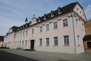 a large white building with a black roof at Helle Nichtraucherwohnung 69qm zwischen Köln und Düsseldorf in Dormagen