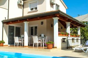 a patio with a table and chairs next to a house at Villa Zare in Poreč