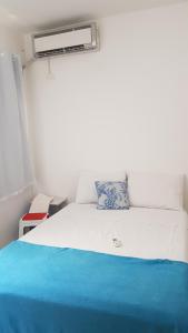 a bedroom with a white bed with a blue blanket at Apartamento no Dalas Park Residencial in Campina Grande