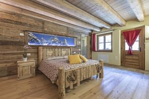 a bedroom with a bed and a tv on a wall at Agriturismo Alle Baite in Branzi +110 photos