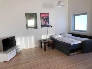 a bedroom with a bed and a flat screen tv at Kang Apartment in Nuuk