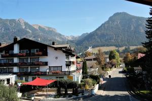 ein Gebäude mit einem roten Regenschirm neben einer Straße in der Unterkunft Alpenflair Ferienwohnungen Whg 223 in Oberstdorf