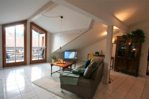ein Wohnzimmer mit einer Couch und einem Tisch in der Unterkunft Alpenflair Ferienwohnungen Whg 223 in Oberstdorf