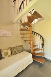 a room with a couch and a spiral staircase at Tassos Apartments in Acharavi