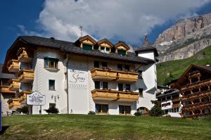 a large white building with wooden balconies on a mountain at B&B Garni Serena in Arabba