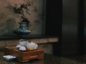 una scatola di legno con due tazze da tè e un vaso di Go Shine Motel a Città di Pingtung