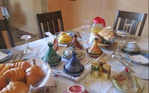 - une table avec des croissants et des vases colorés dans l'établissement Maison Zaitouna, à Marrakech
