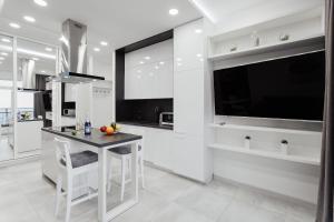 a white kitchen with a table and a large window at Sea Pearl in Odesa