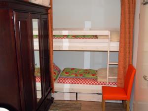 a room with two bunk beds and a red chair at Ferienhaus H.Winkler in Neukalen