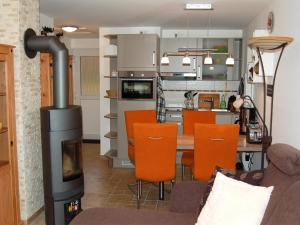 a living room with a wood stove and a kitchen at Ferienhaus H.Winkler in Neukalen