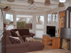 a living room with a couch and a tv at Ferienhaus H.Winkler in Neukalen