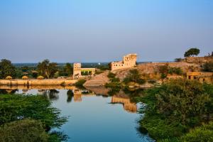 - une vue sur une rivière avec un pont et des bâtiments dans l'établissement Brij Lakshman Sagar, Pali, à Raipur
