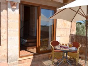 einen Tisch mit 2 Stühlen und einem Sonnenschirm auf einer Terrasse in der Unterkunft Agroturismo Finca Son Sala in Campos