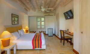 een slaapkamer met een bed, een bureau en een tafel bij Casa Pizarro Hotel Boutique in Cartagena