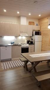 cocina con mesa de madera y suelo de madera en Aurinkolinna 12, en Peräseinäjoki