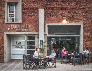 a group of people sitting at tables outside a restaurant at Darwin Apart Hotel in Salta