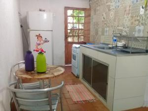 a kitchen with a table and a sink and a refrigerator at Gira Arte Hostel in Recife