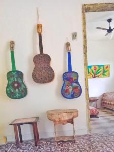 a group of guitars hanging on a wall at Gira Arte Hostel in Recife