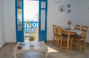 a dining room with a table and chairs and a balcony at Alisachni Villas in Lefkos Karpathou
