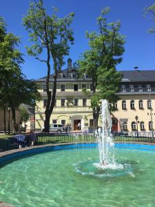 una fuente en una piscina frente a un edificio en Aparthotel Deutscher Kaiser Ferienwohnungen, en Kurort Oberwiesenthal